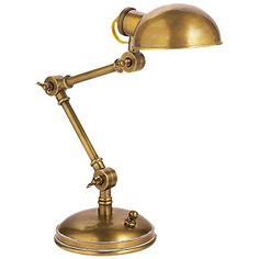 an antique brass desk lamp on a white background