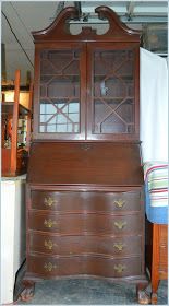 an old wooden dresser with glass doors and drawers