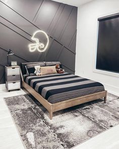 a bedroom with a black and white striped bedspread on the floor next to a window