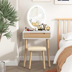 a bedroom with a mirror, vanity table and plant in the corner next to it