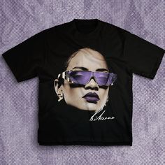 Rihanna Big Face Tshirt | High Quality | Vintage Hip Hop Retro Style 90s Tee This shirt is crafted from 6 oz. of 100% USA-grown cotton, offering a premium and durable build across all our standard colors. For a slight variation, our Heather Grey option blends 90% USA cotton with 10% polyester, ensuring a soft touch with a hint of stretch. Additionally, the Charcoal Grey, Safety Green, and Lime variants present a perfect 50/50 mix of USA cotton and polyester, combining comfort with resilience. Sh Urban Purple Cotton T-shirt, Urban Style Purple Cotton T-shirt, Trendy Purple T-shirt With Logo Print, Purple Letter Print Tops For Streetwear, Urban Purple Short Sleeve T-shirt, Trendy Purple Tops With Logo Print, Purple Summer Tops With Graphic Design, Summer Purple Tops With Graphic Design, Purple Graphic Print Hip Hop Tops