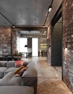 a living room filled with lots of furniture next to a wall covered in brick walls