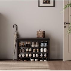 a wooden shelf with several pairs of shoes on it in front of a white door