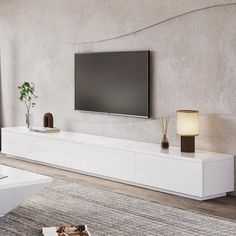 a flat screen tv mounted to the side of a white entertainment center in a living room