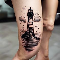 a woman's leg with a lighthouse tattoo on it