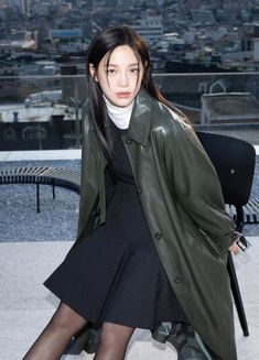 a woman sitting on top of a building with her legs crossed and wearing black stockings