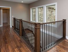 an empty living room with wood floors and white walls