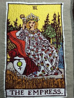 an image of the queen of cups on top of a pillow with trees in the background