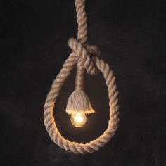 a light bulb hanging from a rope on a black background