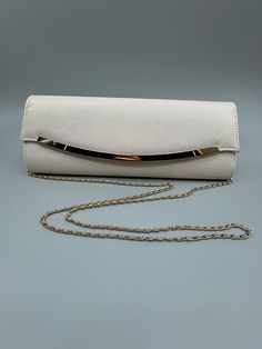 Kate Landry Ivory and gold Evening Bag.  This gorgeous bag is in like new condition - only minor scratches on the gold accent bar.  The ivory is patterned and give off a wonderful shimmer to add to its elegance.  This bag would be a wonderful go to bag for your formal event or wedding!  This bag has classic style and is larger than most formal clutches - so you can keep you makeup, key and purse all in one place - with room to spare.  Ivory satin interior The heavy gold braided chain fully hides inside the bag when you want to use it as a clutch - or allows for a 25" hang.  Bag measure 12" by 4" by 1.5".   Get it - you won't be disappointed!  Free Shipping White Party Bags With Gold-tone Hardware, Luxury Cream Shoulder Bag For Party, Cream Rectangular Evening Bag, Elegant Cream Party Bag, Cream Evening Clutch Bag, Classic Gold Shoulder Bag For Evening, Cream Evening Shoulder Bag For Parties, Cream Rectangular Shoulder Bag For Evening, Cream Evening Shoulder Bag