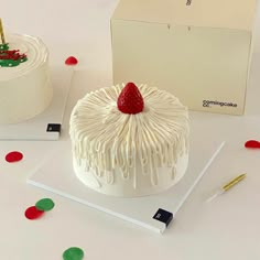 a white cake sitting on top of a table next to a box