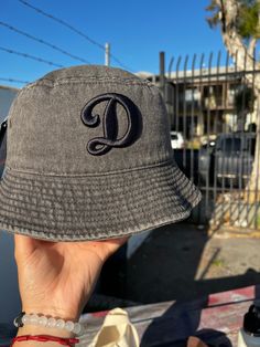 A stylish black Dodgers bucket hat, perfect for sunny days at the ballpark or casual outings, featuring the iconic Dodgers logo embroidered in black, offering both shade and classic flair. Casual Brimmed Baseball Cap With Letter Print, Black Brimmed Casual Baseball Cap, Vintage Black Bucket Hat With Curved Brim, Outdoor Black Snapback Sun Hat, Black Casual Sun Hat For Streetwear, Black Curved Brim Sun Hat For Streetwear, Casual Brimmed Hat With Letter Print, Casual Black Wide Brim Bucket Hat, Black Bucket Hat With Letter Print