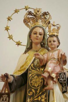 a statue of the virgin mary and child jesus holding a bag with gold stars on it