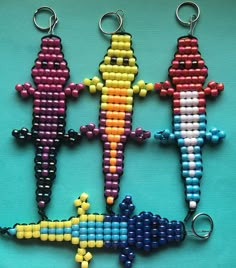 four keychains made to look like different types of lizards on a blue background