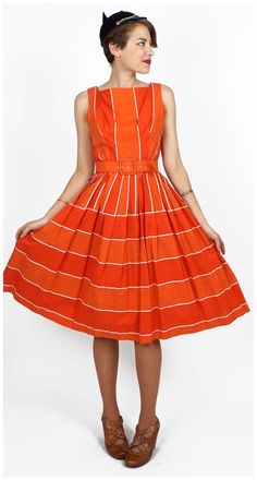 "S T R A I G H T T A L K ▲ Circa: 50s/60s ▲ Tag: Gigi Young ▲ Material: Textured Cotton, Tulle ▲ Condition: Very Good D E T A I L S ▲ Material is a sturdy textured cotton blend ▲ Bright orange, red, & white striped pattern ▲ Sleeveless with square neck ▲ Matching belt ▲ Pleats at waistline ▲ Tulle lining of skirt for extra volume ▲ Bodice is unlined ▲ Covered zipper in back for entry C O N D I T I O N ▲ Very Good Flaws noted: some wear on belt S I Z I N G ▲ Would probably fit a size SMALL be Retro A-line Midi Dress Lined, Retro A-line Midi Dress With Lining, Retro Cotton Dress For Party, Retro Cotton Party Dress, Vintage Orange Midi Dress For Summer, Vintage Orange A-line Dress, Vintage Orange Midi Dress For Spring, Retro Knee-length Midi Dress For Vintage Fashion, Vintage Orange Knee-length Dress