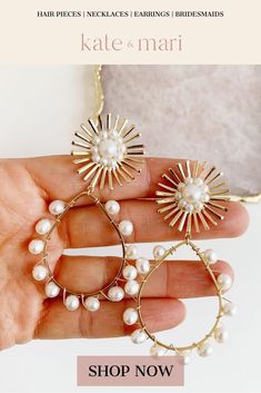 a hand holding two large hoop earrings with pearls on it and the words kate & mari shop now