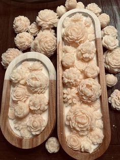 two wooden trays filled with flowers on top of a table