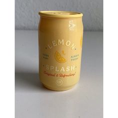 a can of lemon splash sitting on a table next to a white wall and floor