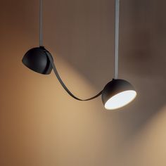 three lights are hanging from the ceiling in a dimly lit room with no one around them