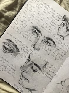 an open book with drawings of different faces and words on it, sitting on a bed