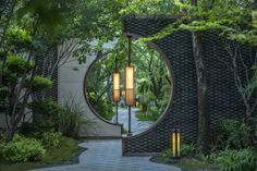 an entrance to a garden with trees and plants around it, surrounded by greenery