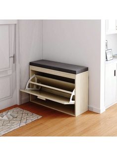 a wooden bench sitting on top of a hard wood floor next to a white door