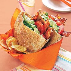 a wrap filled with lots of veggies and chips on top of a table