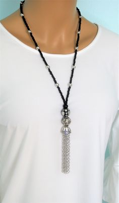 "All of these Tassel Necklaces are handmade by Ralston Originals. These beaded necklaces come in your choice of 5 different Styles. I made all the tassels with silver metal chains, and covered it with a beautiful antique silver metal bead cap. The first necklace is made with black and silver beads (Pictures 1-2). It has a large back bead with silver metal dots, a large silver bead, and black seed beads on the chain, with silver metal beads too. The second necklace is made with black, grey, and s Bohemian Black Beaded Dangle Necklaces, Adjustable Long Tassel Necklace With Dangling Beads, Adjustable Beaded Long Tassel Necklace, Adjustable Beaded Tassel Dangle Necklace, Adjustable Beaded Tassel Necklace With Dangle, Adjustable Beaded Dangle Tassel Necklace, Black Tassel Necklace With Adjustable Fit, Adjustable Beaded Tassel Necklace, Bohemian Long Necklace With Black Round Beads