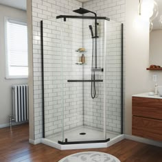 a bathroom with a stand up shower next to a white sink and wooden flooring