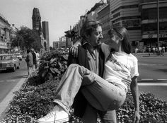 black and white photograph of two people sitting on the curb