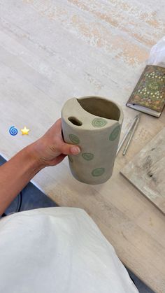 a person holding a cup on top of a table