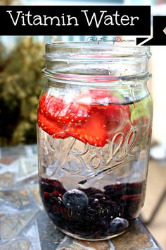 a mason jar filled with blueberries, strawberries and other fruit sitting on top of a table