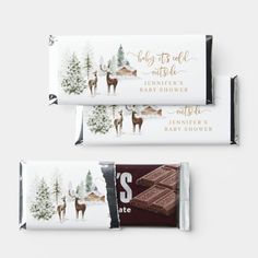 chocolate bar wrappers with reindeer and pine trees on the top, one for baby shower