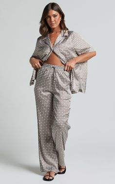 Get ready to step up your loungewear game with our Rosetti Pants in Tessara Geometric Print. These mid waisted, relaxed pants are perfect for those days when you want comfort without compromising on style. Made from a soft and durable polyester fabric, these full-length pants feature an elastic waistband for ease of wear and ultimate comfort. The versatile brown color adds a touch of sophistication to your casual outfits, making them ideal for both lazy weekends at home or running errands around town. Embrace the power of relaxation with our Rosetti Pants - the ultimate fusion of fashion and comfort.Product Details:Relaxed pantFull lengthMid waistMade from polyester fabricPerfect for casual and loungewear occasionsSuitable for winter season Loungewear Sleepwear Trousers With Elastic Waistband, Elastic Waistband Trousers Sleepwear For Loungewear, Sleepwear Trousers With Elastic Waistband For Loungewear, Loungewear Sets With Elastic Waistband And Long Pants, Wide Leg Loungewear Sets, Relaxed Pants, Relax Pants, Winter Season, Geometric Print