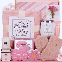 a pink gift hamper filled with personal care items and flowers on top of it