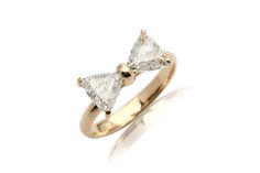 a yellow gold ring with two pear shaped diamonds on the top and one diamond in the middle