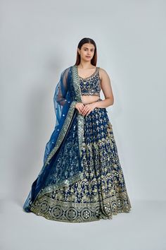 ABOUT Blue lehenga with all-over zari, dabka & nakshi work. Paired with a padded embroidered blouse and mirror work border dupatta. No of Components: 3 Components: Blouse, Dupatta, Lehenga Pattern: Embroidered Type of Work: Dabka, Nakshi, Zari Neckline: Sweetheart Sleeve Type: Sleeveless Fabric: Georgette Color: Blue Embroidered dupatta Please note: Originally stitched in size 36 but can be altered for size 34 without any extra cost. Bollywood Embroidered Choli For Transitional Season, Transitional Bollywood Embroidered Choli, Diwali Embroidered Semi-stitched Lehenga, Festive Bollywood Embroidered Lehenga, Bollywood Semi-stitched Choli For Diwali, Floor-length Embroidered Choli For Diwali, Diwali Semi-stitched Choli With Intricate Embroidery, Eid Embroidered Semi-stitched Choli, Festive Choli With Intricate Embroidery