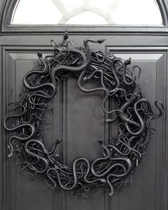 a wreath with black snakes hanging on the front door