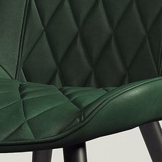 a green leather chair sitting on top of a wooden table