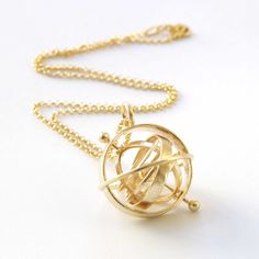 An Armillary Sphere is an ancient astronomical device, originating from China in the 4th century BC and Greece in the 3rd century BC. It depicts the positions of celestial objects in the sky. The pendant is based on the Ptolemaic armillary sphere, placing Earth at the center, in contrast to the Copernican armillary sphere, where the Sun is at the center. One complete rotation of the central axis of the Ptolemaic armillary sphere represents 24 hours. The three narrow central bands correspond to t Armillary Rings, Armillary Sphere Aesthetic, Armillary Sphere Necklace, Sphere Necklace Pendants, Planet Jewelry, Tropic Of Capricorn, Armillary Sphere, Celestial Sphere, Science Jewelry