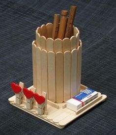 there is a small wooden cup holder with pencils in it