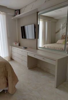 a bedroom with a bed, dresser and large mirror on the wall above it's headboard