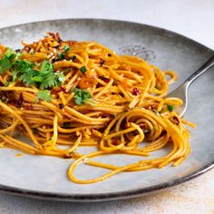 a plate full of spaghetti with parsley on top