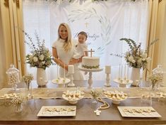 a woman standing next to a little boy in front of a cake on a table