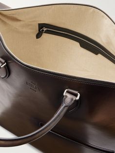 Arrive at your destination in style with Berluti's weekend bag. It's been handcrafted in Italy from signature Venezia leather, which boasts a rich patina and is equipped with handy features like a trolley loop and detachable adjustable shoulder strap. The neatly compartmented, canvas-lined interior will fit all the essentials. Luxury Everyday Satchel With Leather Lining, Luxury Cognac Briefcase With Luggage Sleeve, Luxury Satchel With Luggage Sleeve For Daily Use, Luxury Brown Weekender Bag For Business, Luxury Cognac Travel Bag For Business Trips, Luxury Brown Duffle Bag For Business Trips, Luxury Briefcase Tote With Luggage Sleeve, Luxury Briefcase With Luggage Sleeve Tote Shape, Luxury Saffiano Leather Satchel With Leather Handles