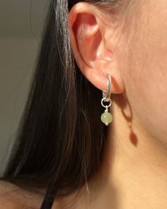 This pair of mossy-green dangle earrings will be your go-to piece. Shinny 6-7mm round nephrite, a variation of jade known for its exceptionally deep green hue, matches with minimal S925 Sterling Silver hoop earrings. ✿ Sold in a pair ✿ Material: 6-7mm /0.24-0.28in Natural Round Nephrite ✿ Finish: 15mm S925 Sterling Silver Huggie Hoops ✿ Approx. 1 inch in length and 0.6 inch in width ✿ Tarnish resistant, hypoallergenic, safe for sensitive skin Green Sterling Silver Huggie Earrings, Green Sterling Silver Hoop Earrings For May Birthstone, Dainty Green Round Hoop Earrings, Dainty Green Hoop Earrings, Green Sterling Silver Small Hoop Earrings, Minimalist Green Hoop Earrings With Ear Wire, Mossy Green, Gold Bond, Sterling Silver Hoop Earrings