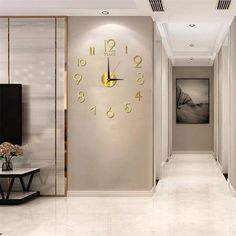 a large clock is on the wall in this modern living room with beige walls and white flooring