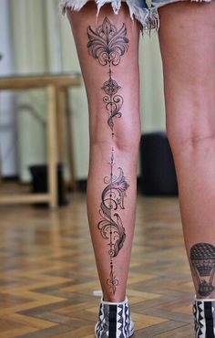 the legs and ankles of a woman with tattoos