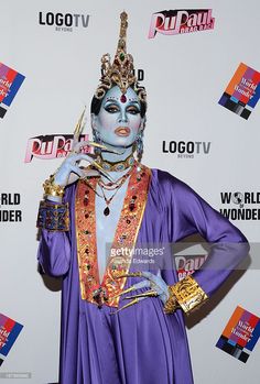 a woman dressed in purple and gold poses for the camera