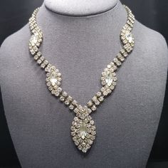 *Description: This is a gorgeous mid-century clear rhinestone necklace with a hanging rhinestone pendant from the 1950s.  This necklace would be beautiful for a wedding or any formal event.  It has clear rhinestones which are prong set on a silver tone backing.  The clasp is a hook which allows you to adjust the length up to 17 1/2 Inches.  This would be a great addition to your vintage jewelry collection or make a great vintage gift! *Approximate Measurements: Length - 17 1/2 Inches, Pendant Le Vintage Diamond White Diamond Necklace, Oval Diamond Necklaces For Party, Oval Crystal Jewelry With Rhinestones, Costume Jewelry Crystal Necklaces With Rhinestones For Wedding, Vintage Diamond Wedding Necklace, Vintage Crystal Bridal Necklace, Vintage Diamond Necklace For Evening, Elegant Necklaces With Sparkling Stones For Vintage Events, Vintage Diamond White Necklace For Wedding